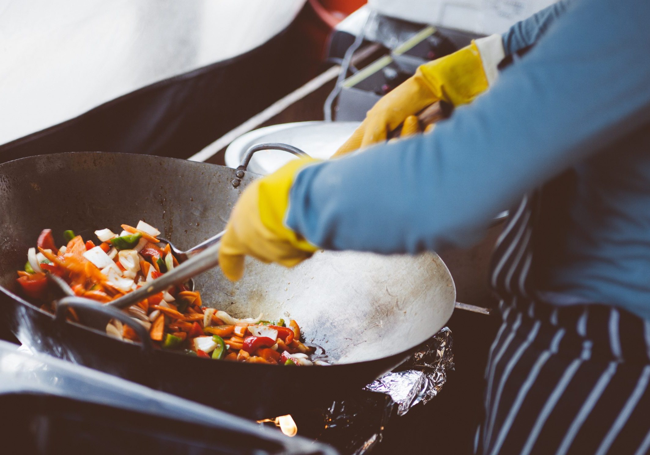 person mixing vegetable in wok